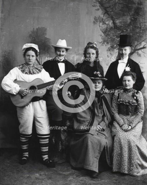 Six dressed-up youngsters, one of the young people plays the guitar, 1910-1920. Creator: Hans Per Persson.