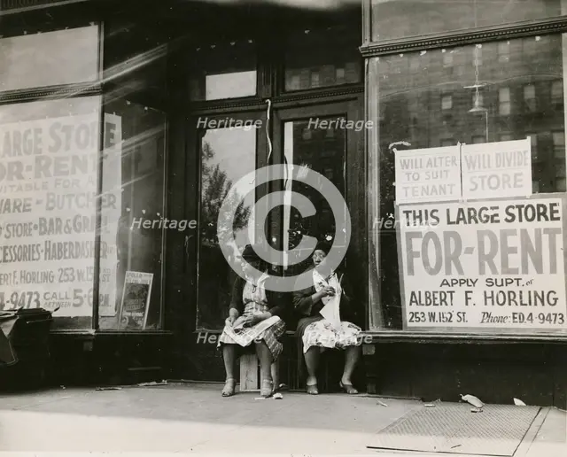 Sidewalk sitters. Two women sitting in doorway of empty storefront that is being..., ca. 1930s. Creator: Unknown.