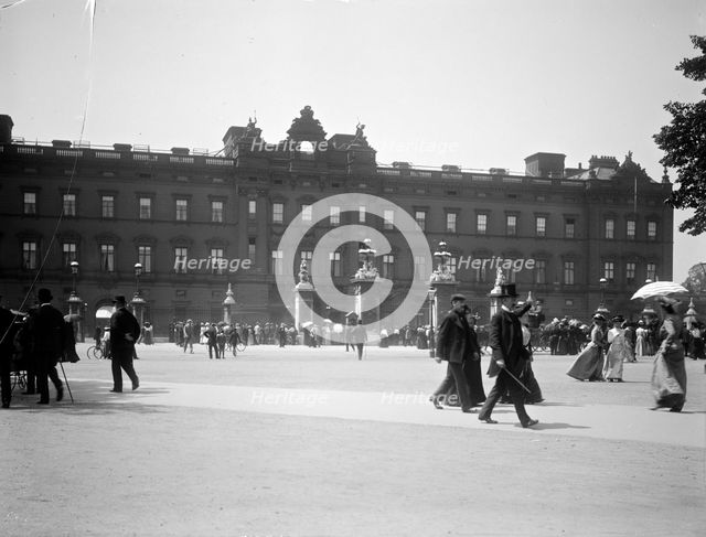 Sightseers crowd around the gates of Buckingham Palace, London. Artist: Unknown