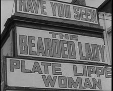 Signs at a Seaside Show HAVE YOU SEEN 'THE BEARDED LADY 'PLATE LIPPED WOMAN 1938. Creator: British Pathe Ltd