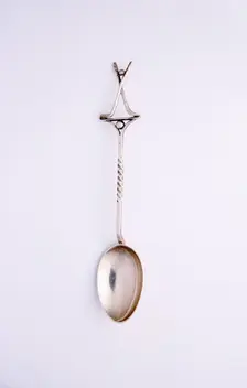Silver spoon with two crossed clubs and ball, British, 1922. Creator: Unknown