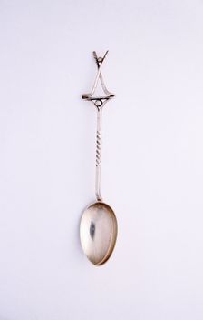 Silver spoon with two crossed clubs and ball, British, 1922. Creator: Unknown