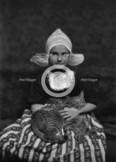 Silvester child with Buzzer the cat, portrait photograph, 1913 Mar. 3. Creator: Arnold Genthe.