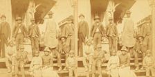Simplicity, Alabama, U.S.A. [Group gathered on a porch, in town], (1868-1900?). Creator: Benjamin West Kilburn
