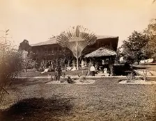 Singapore: a large bungalow with people having drinks in the garden around a large..., 1881. Creator: John Edmund Taylor