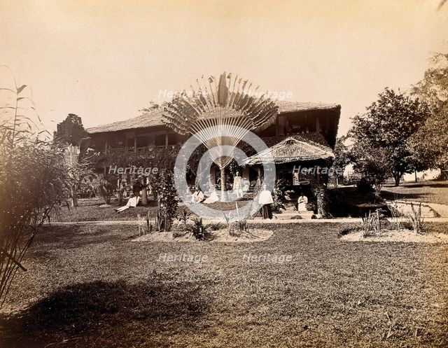 Singapore: a large bungalow with people having drinks in the garden around a large..., 1881. Creator: John Edmund Taylor.