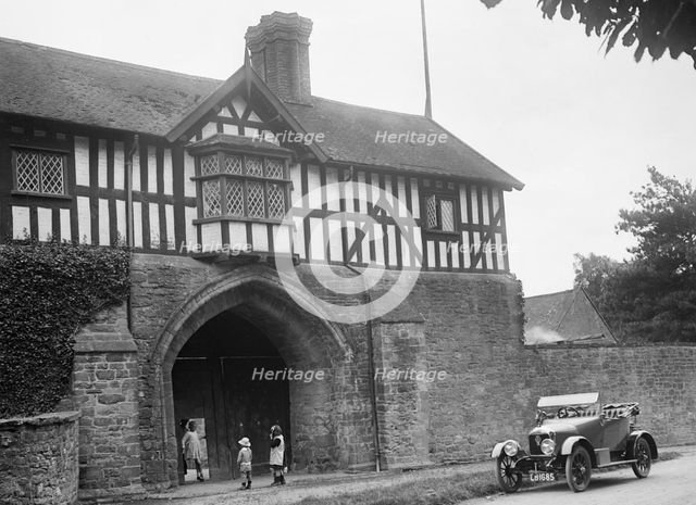 Singer 10 hp open 2-seater by the gatehouse of Stokesay Castle, Shropshire, 1920s. Artist: Bill Brunell.