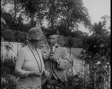 Sir Harry Lauder Giving Flowers to His Wife, Lady Ann Lauder, at Home in Scotland, 1920s. Creator: British Pathe Ltd