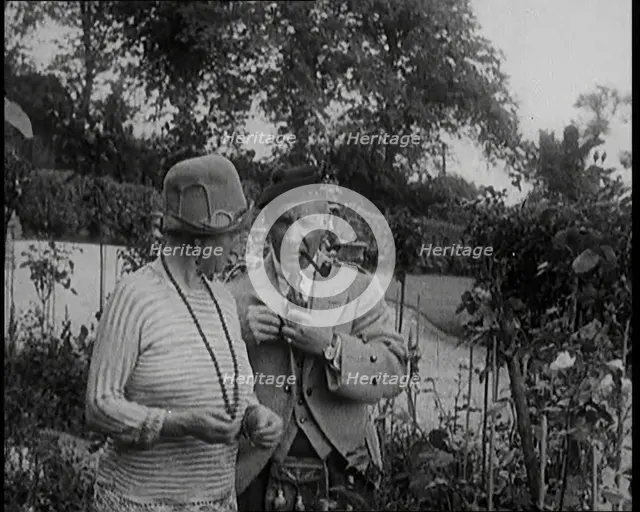 Sir Harry Lauder Giving Flowers to His Wife, Lady Ann Lauder, at Home in Scotland, 1920s. Creator: British Pathe Ltd.