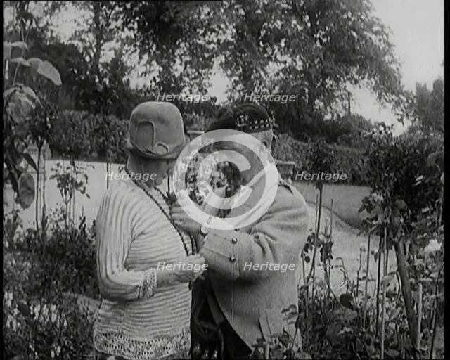 Sir Harry Lauder Giving Flowers to His Wife, Lady Ann Lauder, at Home in Scotland, 1920s. Creator: British Pathe Ltd.