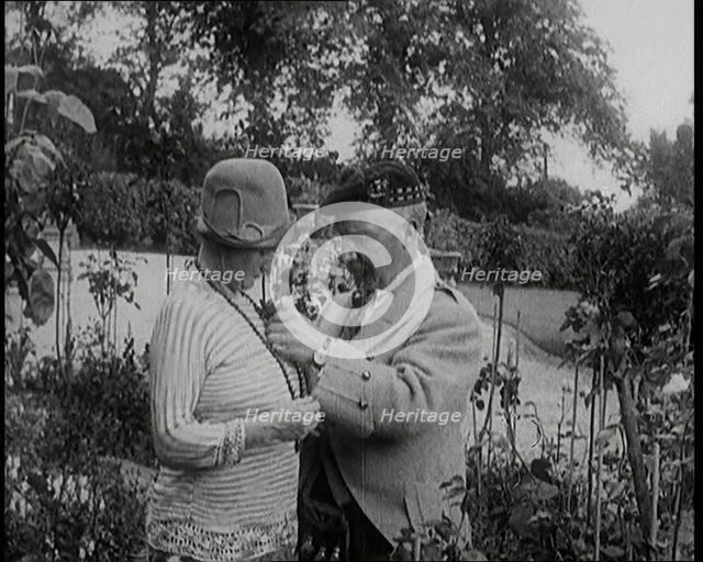 Sir Harry Lauder Giving Flowers to His Wife, Lady Ann Lauder, at Home in Scotland, 1920s. Creator: British Pathe Ltd.