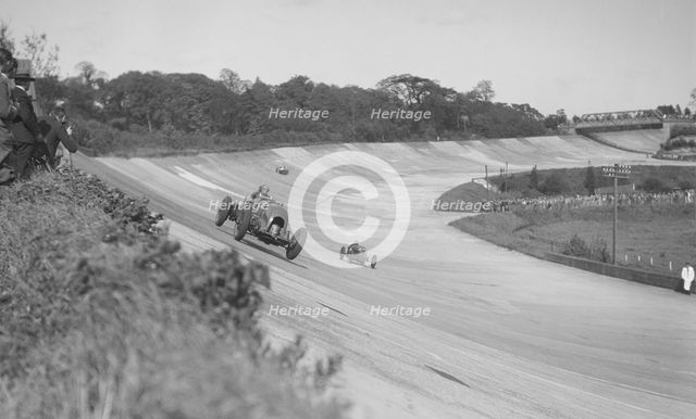 Sir Henry Birkin's Bentley leading Earl Howe's Bugatti Type 54, BARC meeting, Brooklands, May 1932. Artist: Bill Brunell.