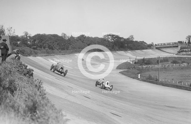 Sir Henry Birkin's Bentley racing RJ Munday's Vauxhall 30/98, BARC meeting, Brooklands, 16 May 1932. Artist: Bill Brunell.