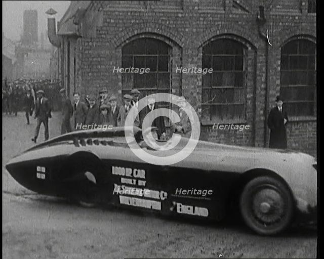 Sir Henry Segrave AKA Major Segrave's Driving  'Sunbeam' Out of a Factory Watched By a..., 1927. Creator: British Pathe Ltd.