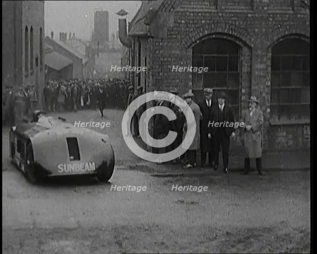 Sir Henry Segrave AKA Major Segrave's Driving  'Sunbeam' Out of a Factory Watched By a..., 1927. Creator: British Pathe Ltd.