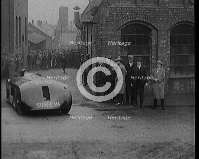 Sir Henry Segrave AKA Major Segrave's Driving  'Sunbeam' Out of a Factory Watched By a..., 1927. Creator: British Pathe Ltd.