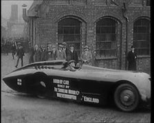 Sir Henry Segrave AKA Major Segrave's Driving Sunbeam Out of a Factory Watched By a..., 1927. Creator: British Pathe Ltd