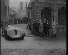 Sir Henry Segrave AKA Major Segrave's Driving Sunbeam Out of a Factory Watched By a..., 1927. Creator: British Pathe Ltd