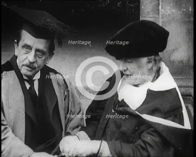 Sir James Barrie and Ellen Terry Sitting Together in Academic Dress Outside St Andrew's Uni, 1922. Creator: British Pathe Ltd.
