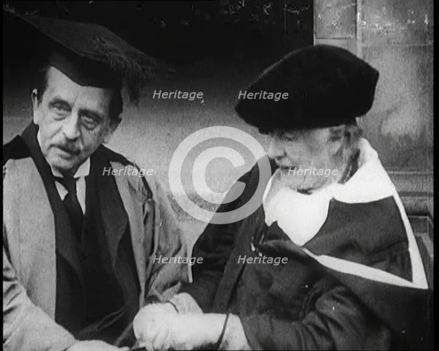 Sir James Barrie and Ellen Terry Sitting Together in Academic Dress Outside St Andrew's Uni, 1922. Creator: British Pathe Ltd.