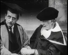 Sir James Barrie and Ellen Terry Sitting Together in Academic Dress Outside St Andrew's Uni, 1922. Creator: British Pathe Ltd
