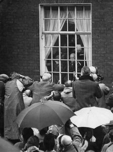 Sir Winston Churchill waving from his Hyde Park Gate window on the eve of his 90th birthday, 1964
