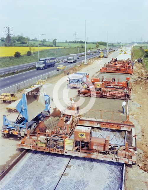 Slipform paving machines laying a road surface during widening works on the M1, 18/05/1982. Creator: John Laing plc.