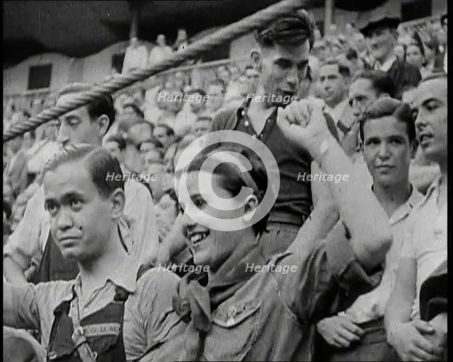 Spectators at Bullring Cheering Parading Government Fighters, Including Woman With Raised..., 1937. Creator: British Pathe Ltd.