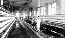 Spinning the cotton into yarn: a great spinning-mule in use, 1909. Creator: Unknown