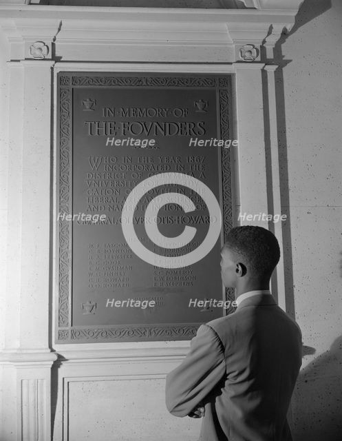 Student reading bronze plaque in library of Howard University, Washington, D.C., 1942. Creator: Gordon Parks.