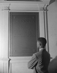 Student reading bronze plaque in library of Howard University, Washington, D.C., 1942. Creator: Gordon Parks
