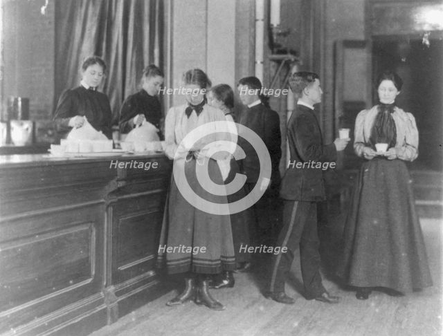Students getting beverages from a counter, Western High School, Washington, D.C., (1899?). Creator: Frances Benjamin Johnston.