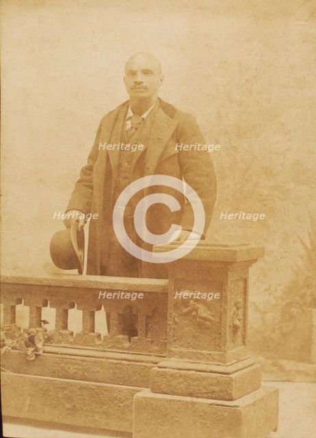Studio portrait of man dressed in suit and coat, holding bowler hat, c1890. Creator: Steinhardt.