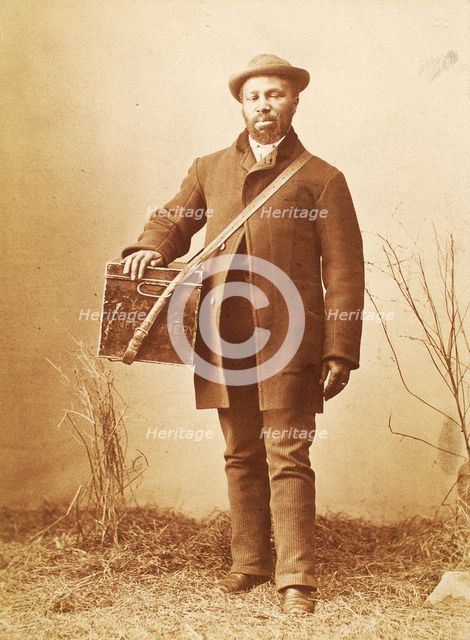 Studio portrait of man holding box labelled 'Confectionery', c1880. Creator: William Notman.
