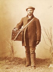 Studio portrait of man holding box labelled Confectionery c1880. Creator: William Notman