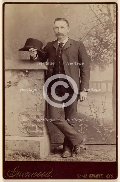 Studio portrait of a man holding a hat, about 1885. Creator: WH Greenwood.