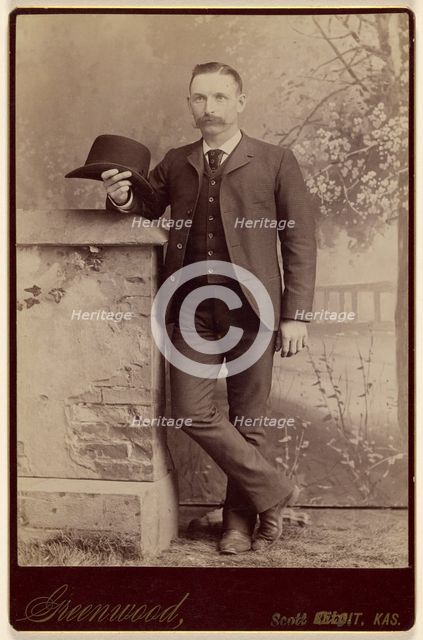 Studio portrait of a man holding a hat, about 1885. Creator: WH Greenwood.