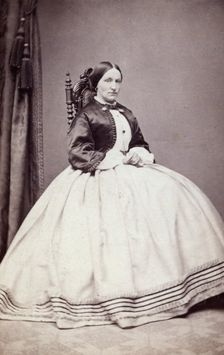 Studio portrait of a young woman in an ankle-length dress, late 19th century(?). Creator: Unknown