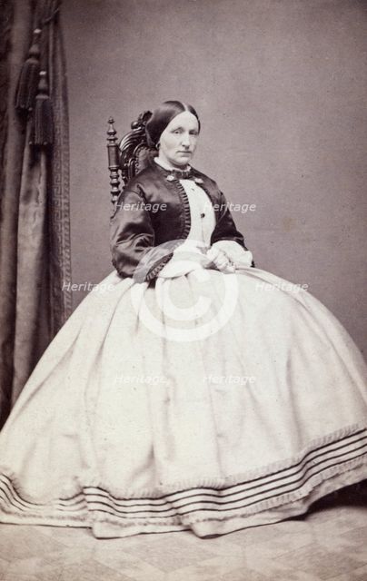 Studio portrait of a young woman in an ankle-length dress, late 19th century(?). Creator: Unknown.