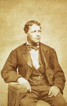 Studio portrait of unidentified seated young man, his left arm resting on chair, c1870-c1879. Creator: Unknown
