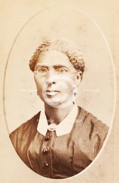 Studio portrait of woman wearing glasses and cross-shaped earrings, c1880-c1889. Creator: George Daniels Morse.