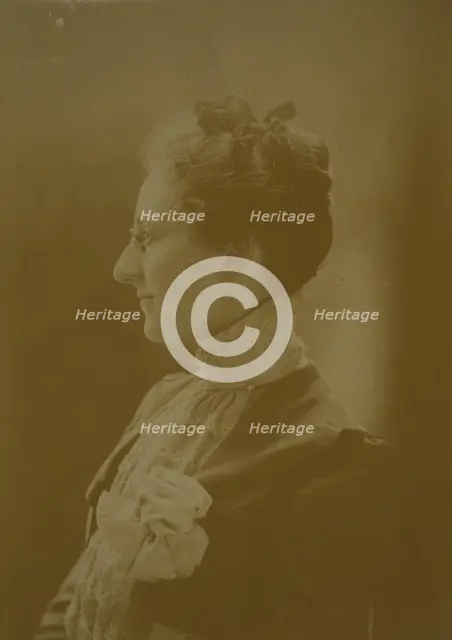 Studio portrait of young woman in white dress posed as if holding flowering tree branch, c1900. Creator: Unknown.