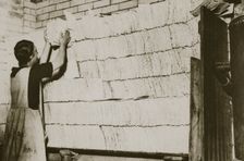 Stacking unleavened bread for the Passover in a Jewish bakery, 20th century. Creator: Unknown