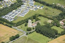 Static caravans and the Church of St Bartholomew, Corton, Suffolk, 2019. Creator: Historic England