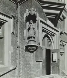Statue of a girl scholar beside the door, Hamlet of Ratcliff Schools, Stepney, London, 1945