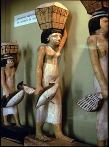 Statue of a peasant woman carrying products of the land to a dead man, made in polychromed wood. …