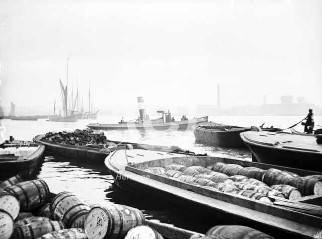 Steam tug moving between barges on the Thames, London, c1905. Artist: Unknown