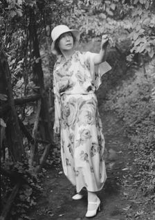 Stettheimer, Florine, Miss, standing outdoors, 1931 Aug. 19. Creator: Arnold Genthe