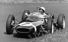 Stirling Moss taking a bend in a racing car, (c1960-c1961?)