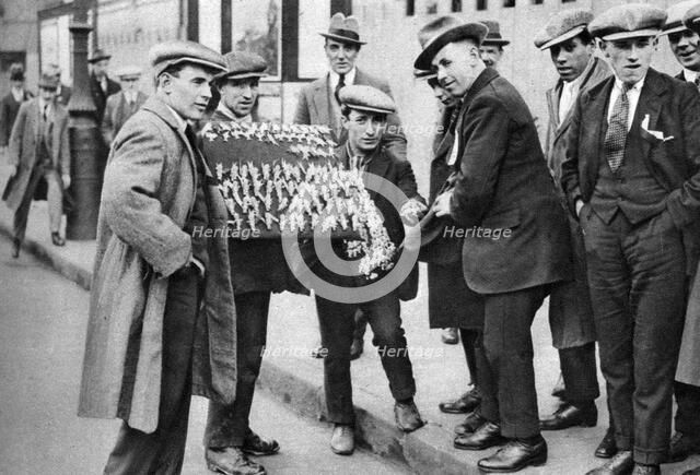 Street hawker selling football favours in King's Cross, London, 1911 (1926-1927). Artist: Unknown